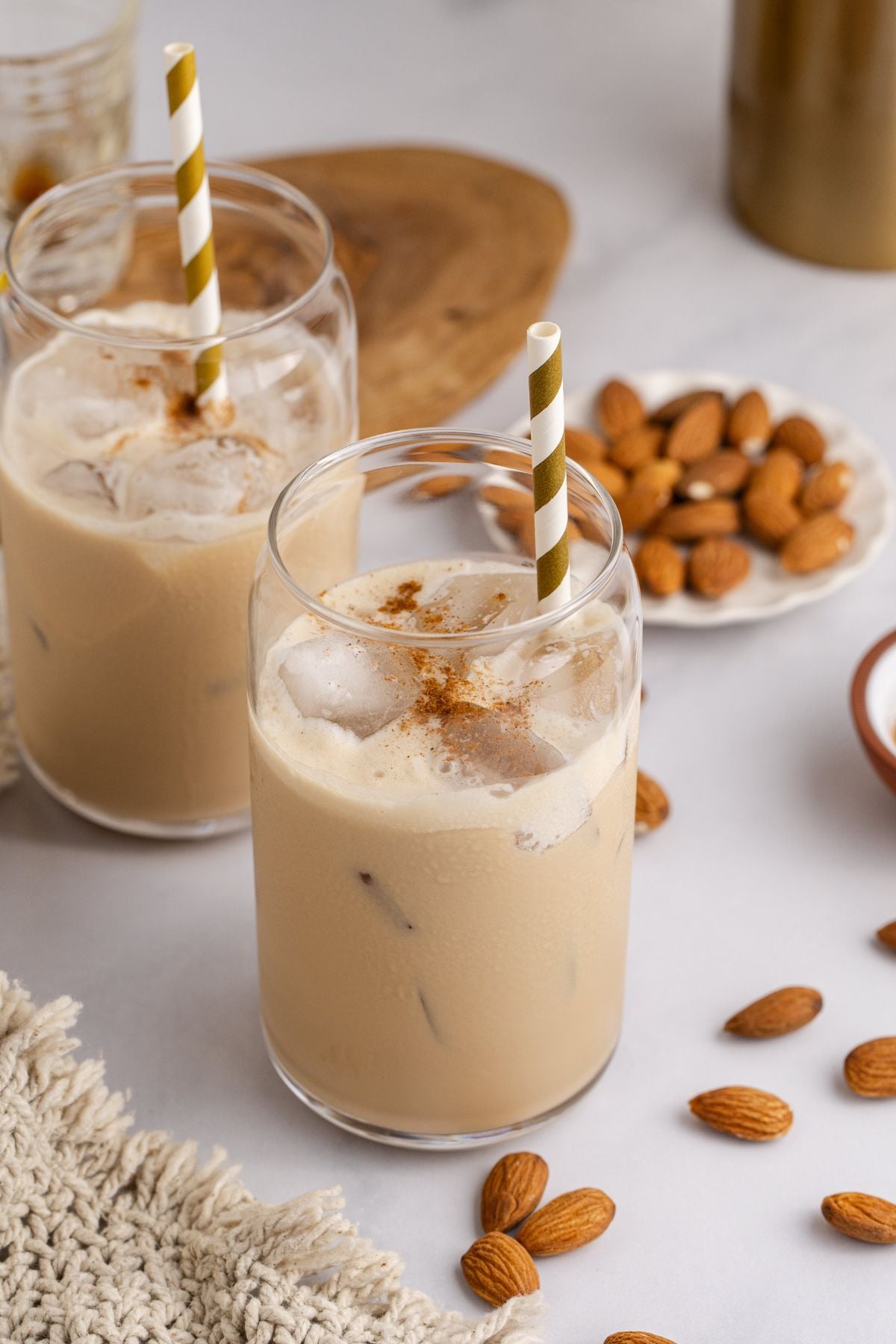 Cocktails on a table with some whole almonds.