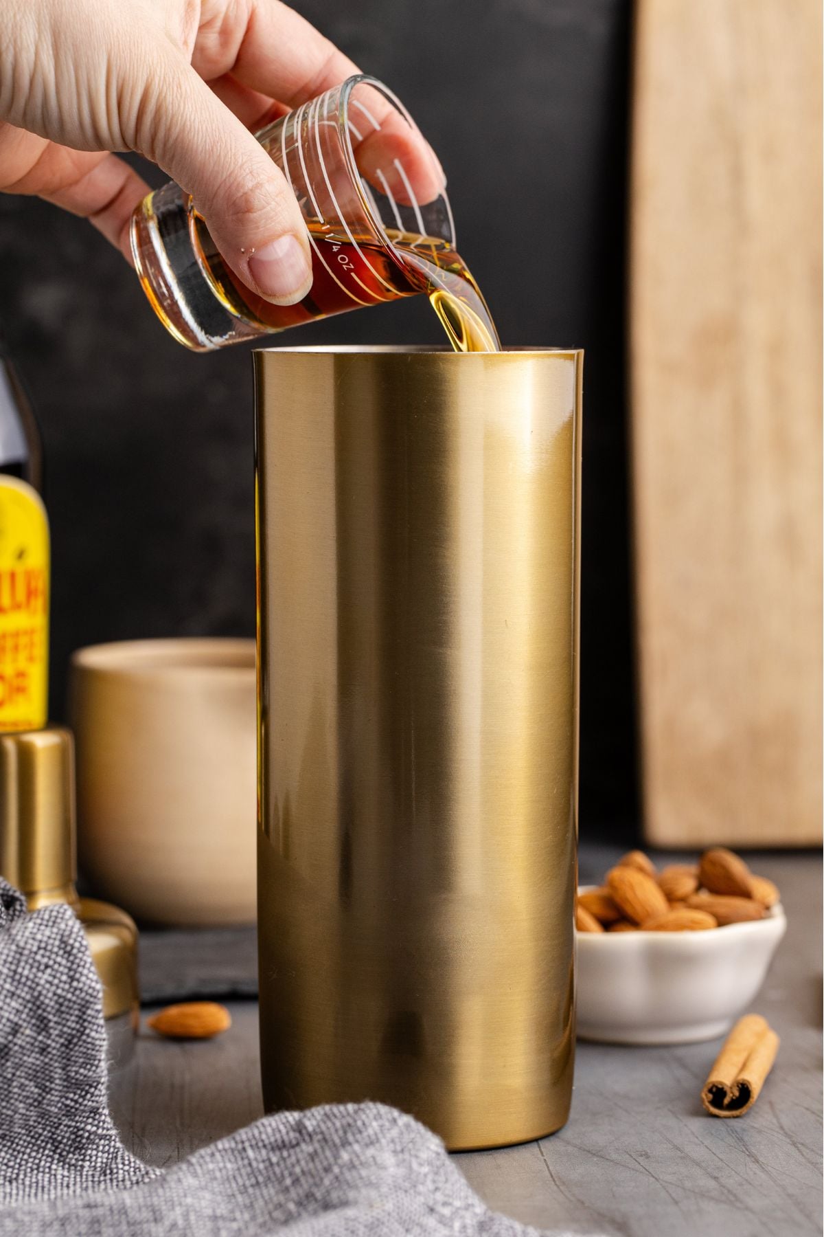 Cocktail shaker filled halfway with ice cubes, heavy cream, Kahlúa, and Amaretto being added.