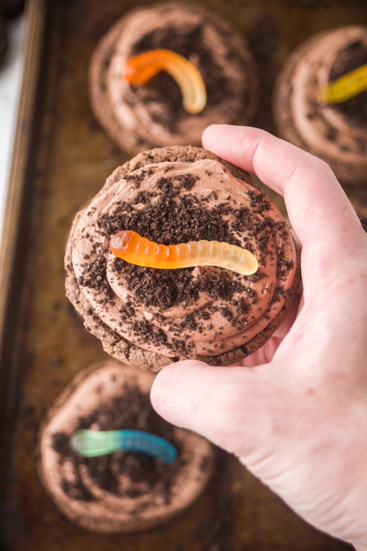 One dirt cake cookie being held up in the air.