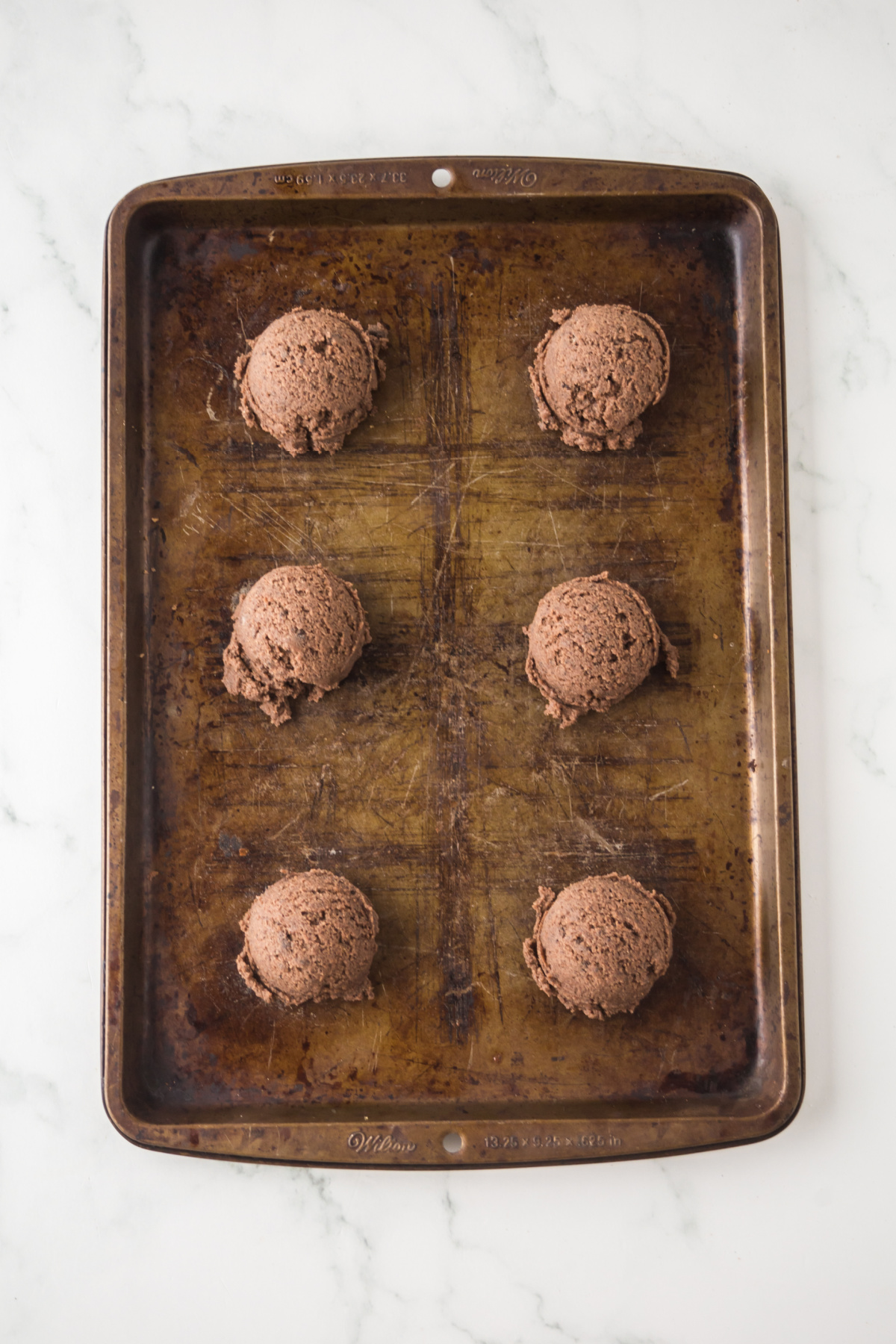 The dough formed into balls on a cookie sheet.