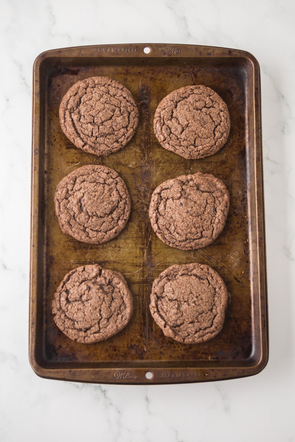 Cookies baked and cooling on a cookie sheet.