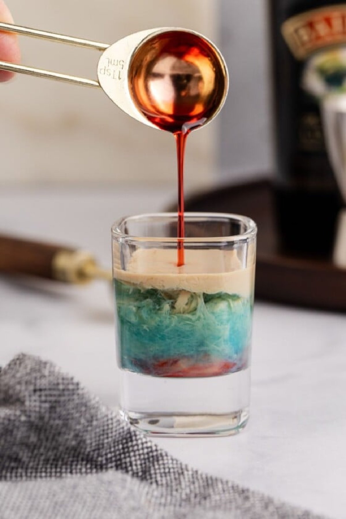 The blue curacao and grenadine added to shot.