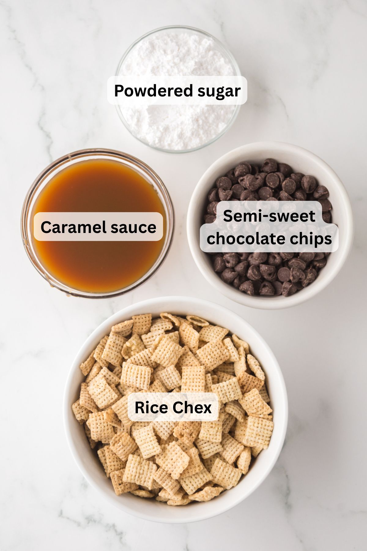 All of the ingredients needed to make Chocolate Caramel Muddy Buddies in bowls on a table.