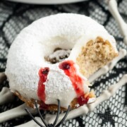 A vampire donut in a skeleton hand.