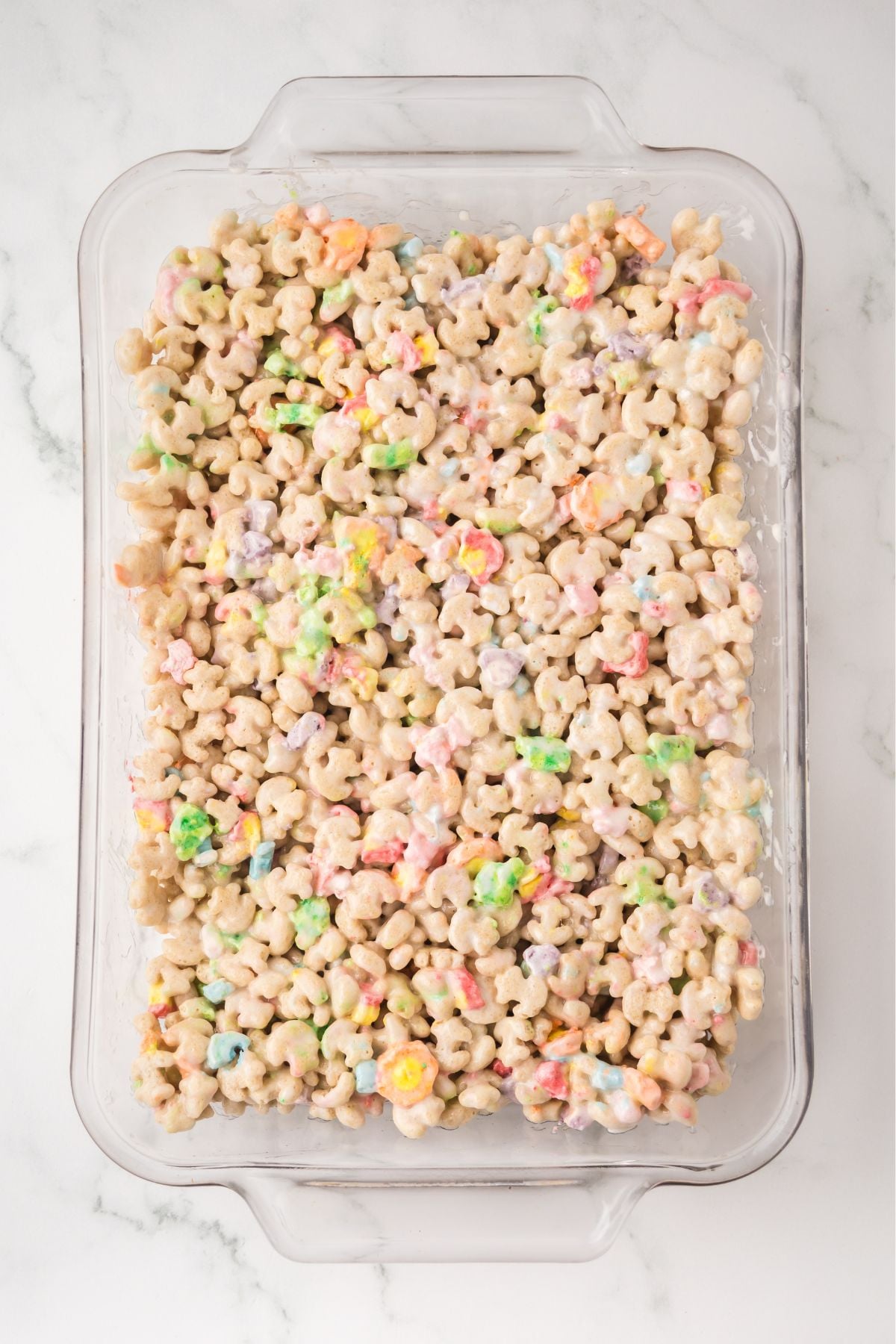 Lucky Charms cereal mixture pressed down into the baking dish.