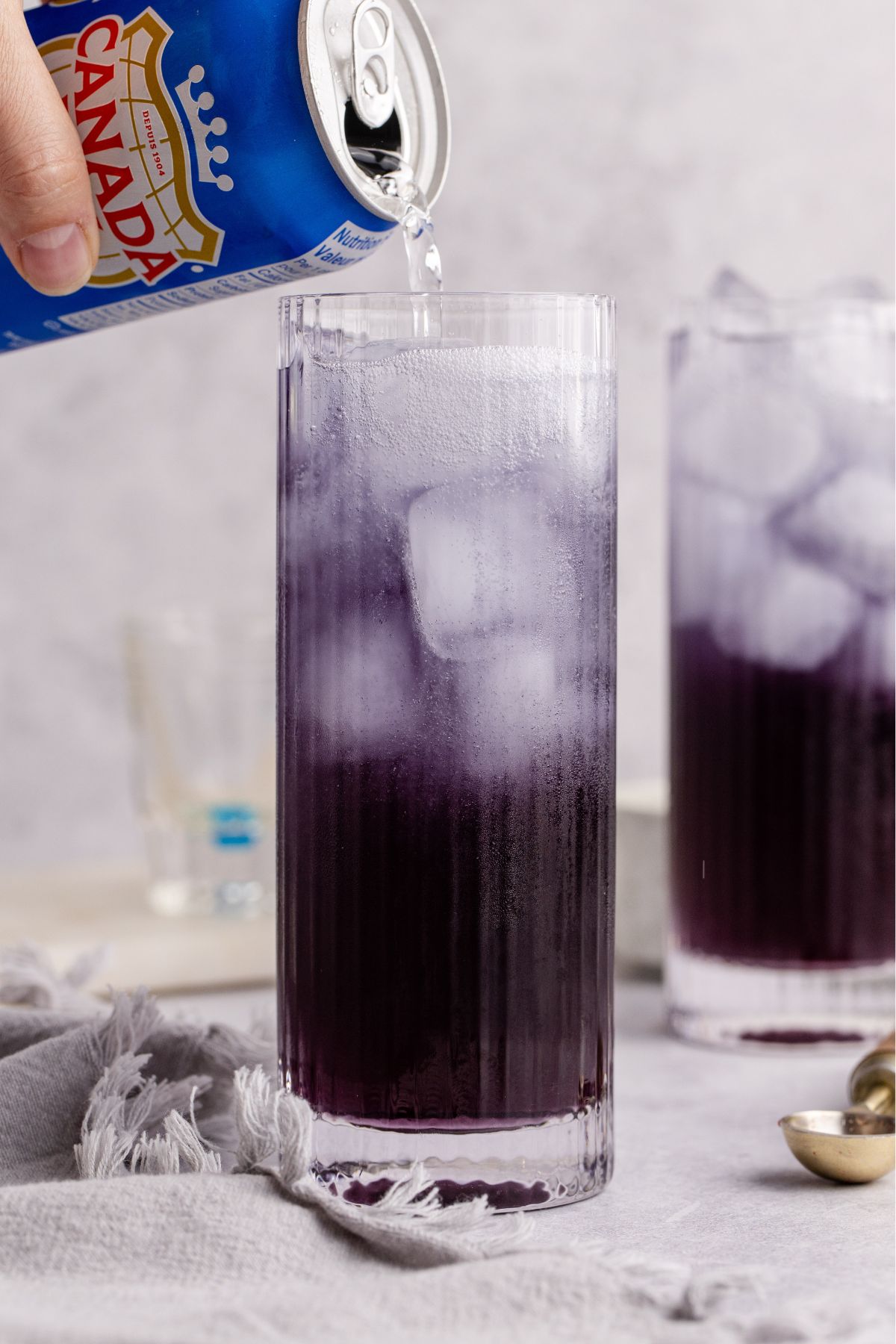 Club soda being added to drink.