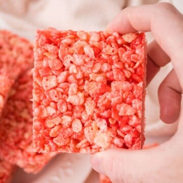 A strawberry rice krispie treat held in the air.