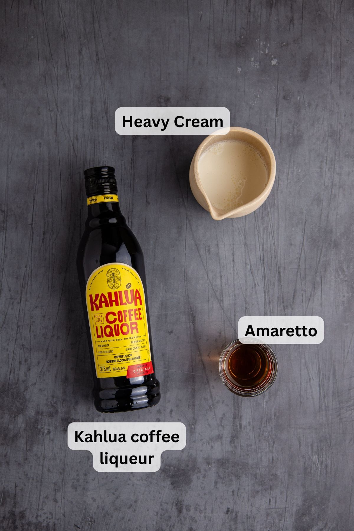 Heavy cream, Kahlúa coffee liqueur, and Amaretto for making a Toasted Almond Cocktail on a table.