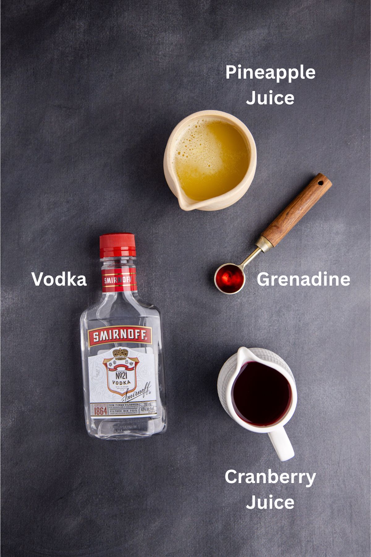 Ingredients to make love bug cocktail on the table with labels to identify each one.