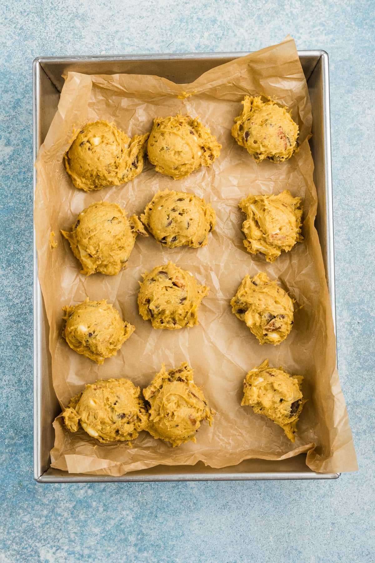 The cookie dough scooped onto a pan.