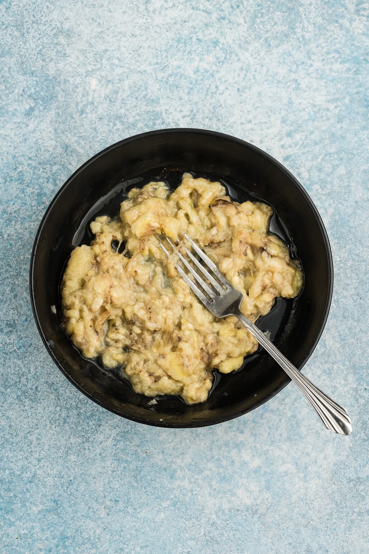 Bananas mashed in a bowl.