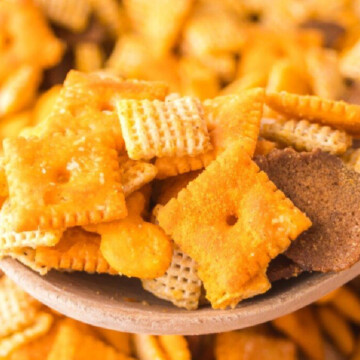 A spoonful of chex mix over bowlful.