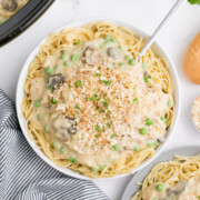 A bowl full of crockpot chicken tetrazzini with a spoon.