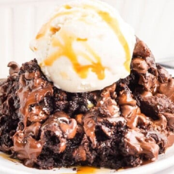 A scoop of pudding cake on plate with scoop of ice cream.