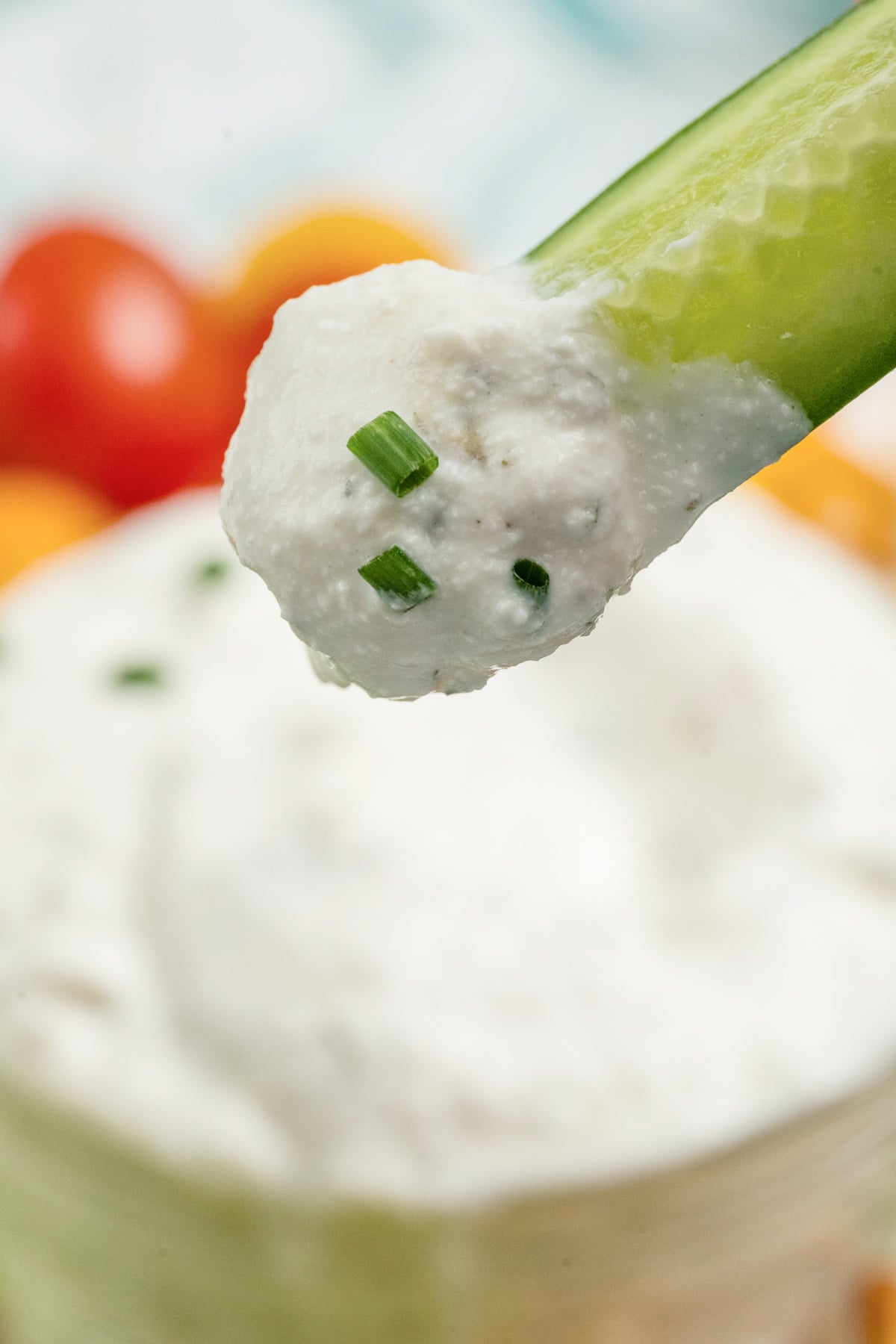 A cucumber dipped and held in the air.