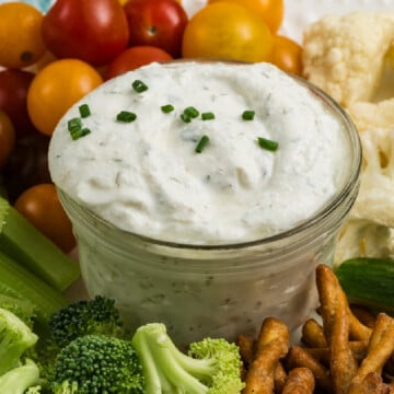 A bowl of Cottage Cheese Ranch Dip surrounded by different vegetables on a platter.