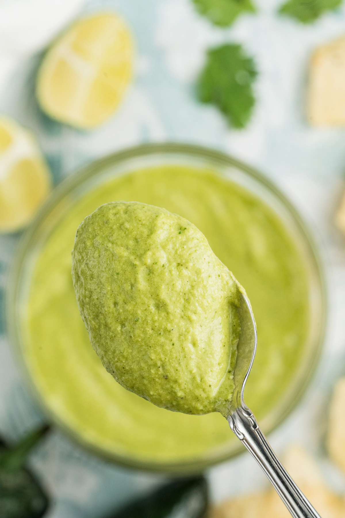 A spoonful of creamy poblano sauce held in the air.