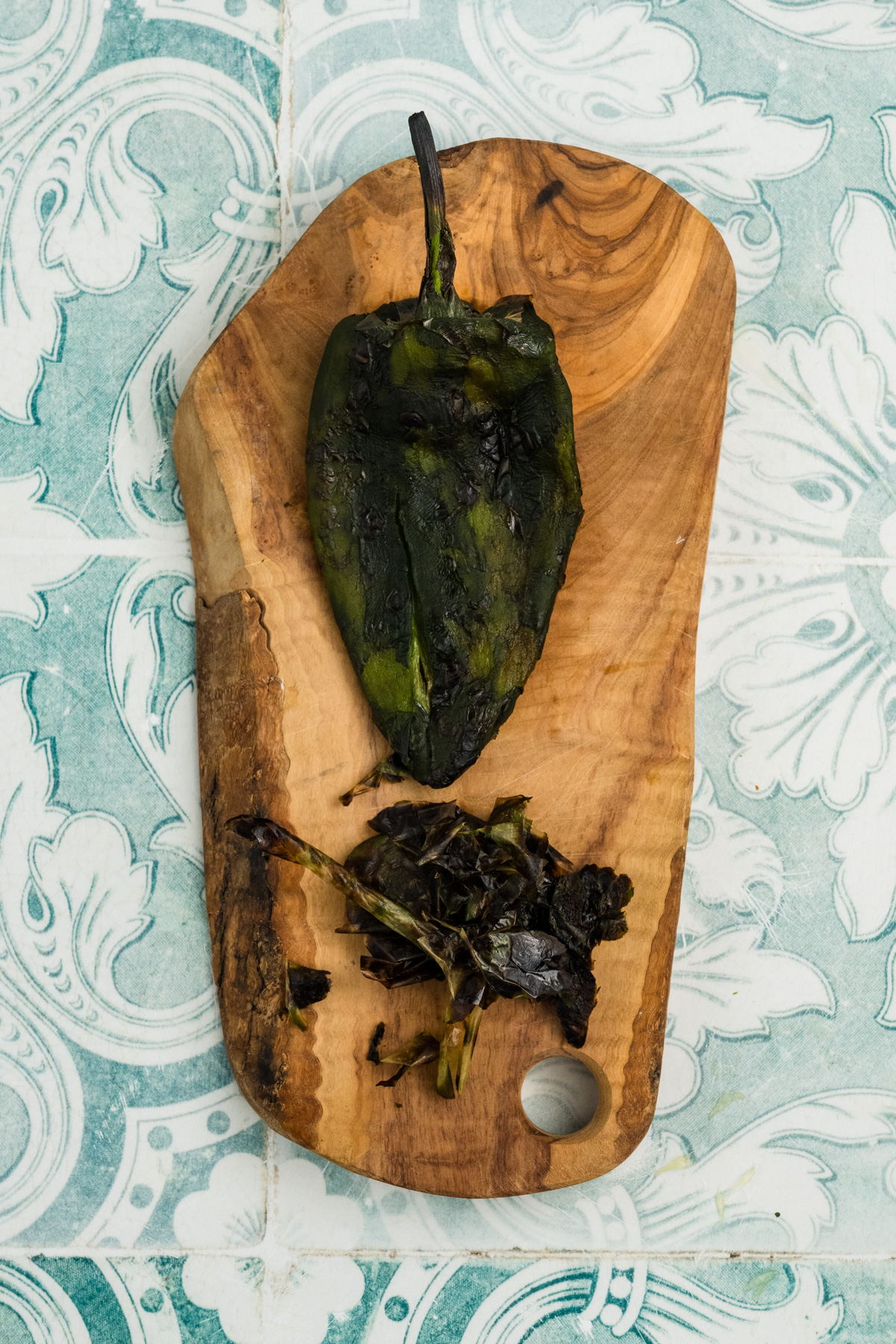 Removed skin on a cutting board wih poblano  flesh.