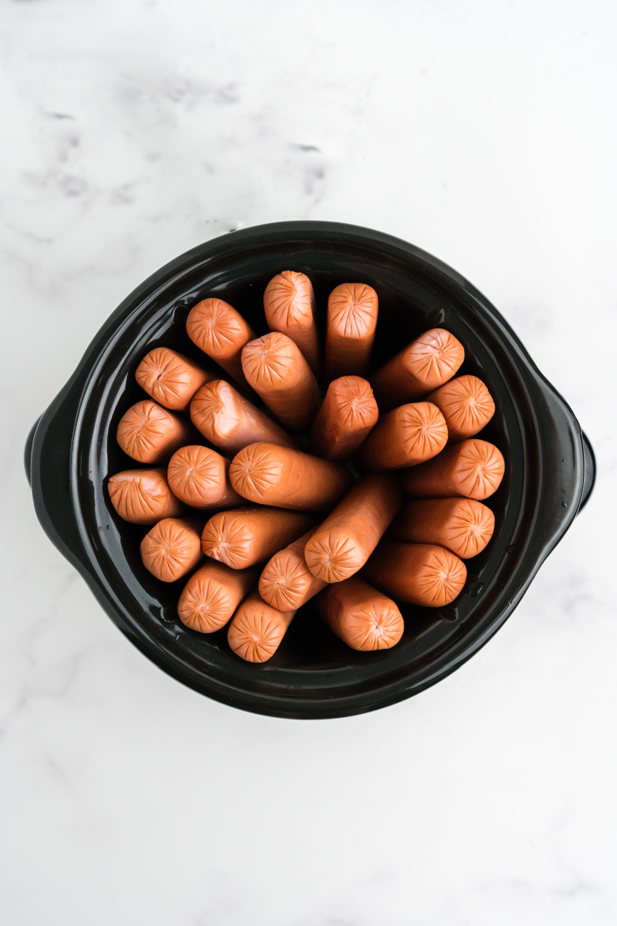 Hot dogs put into a crock pot.