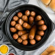 Crock pot hot dogs piled in a slow cooker.