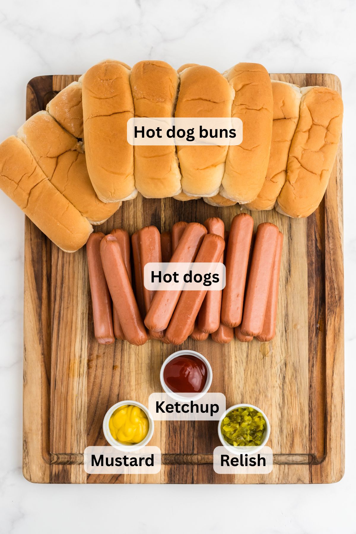 Ingredients to make these hot dogs on a cutting board.