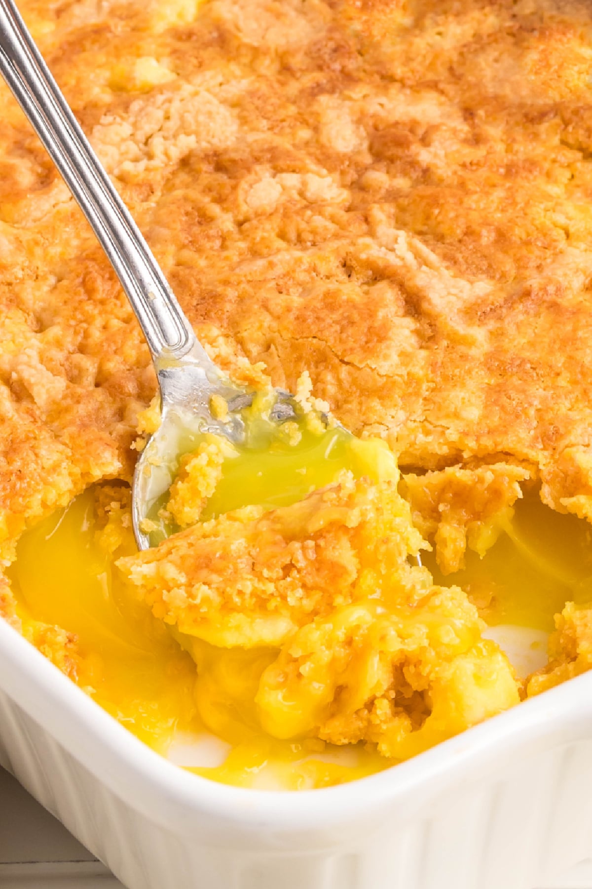 Cream cheese cake being scooped out of a dish.