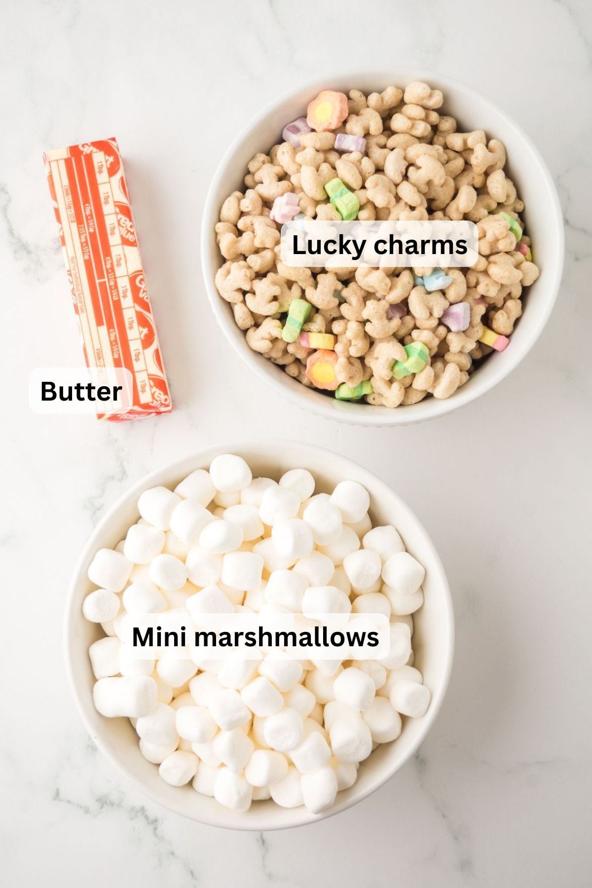 Ingredients to make these rice krispie treats in bowls on a table.