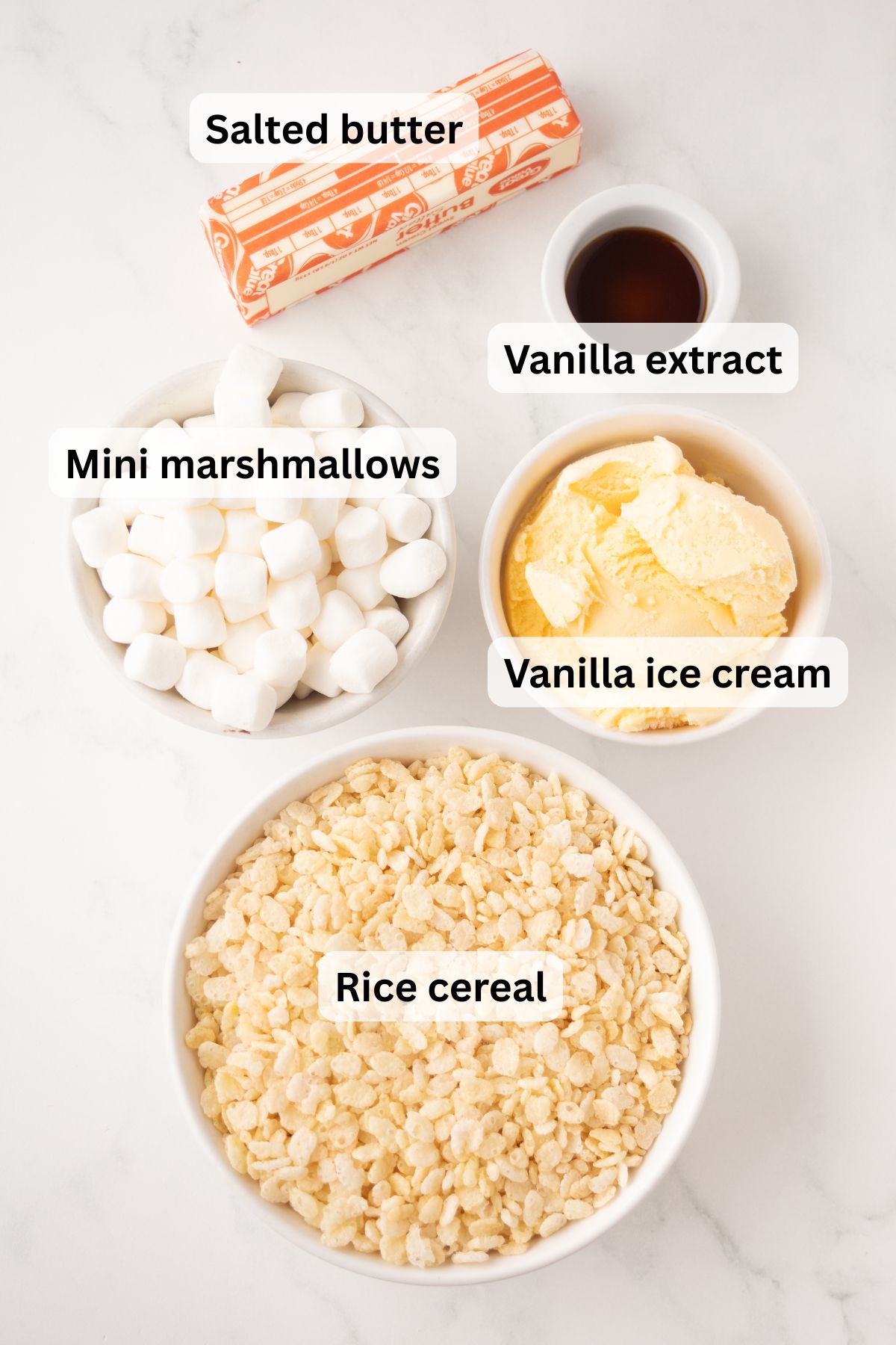 All of the ingredients needed to make Rice Krispie Ice Cream Sandwiches in bowls on a table.