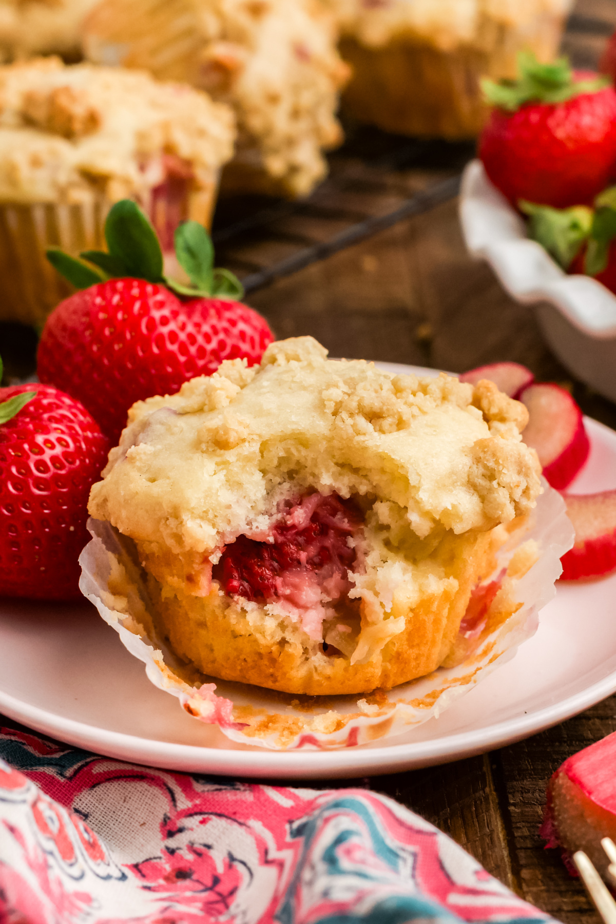 A muffin with strawberry rhubarb on a plate.