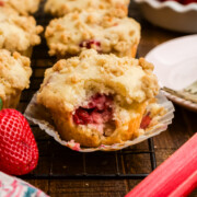 Strawberry rhubarb muffins with a bite taken out.