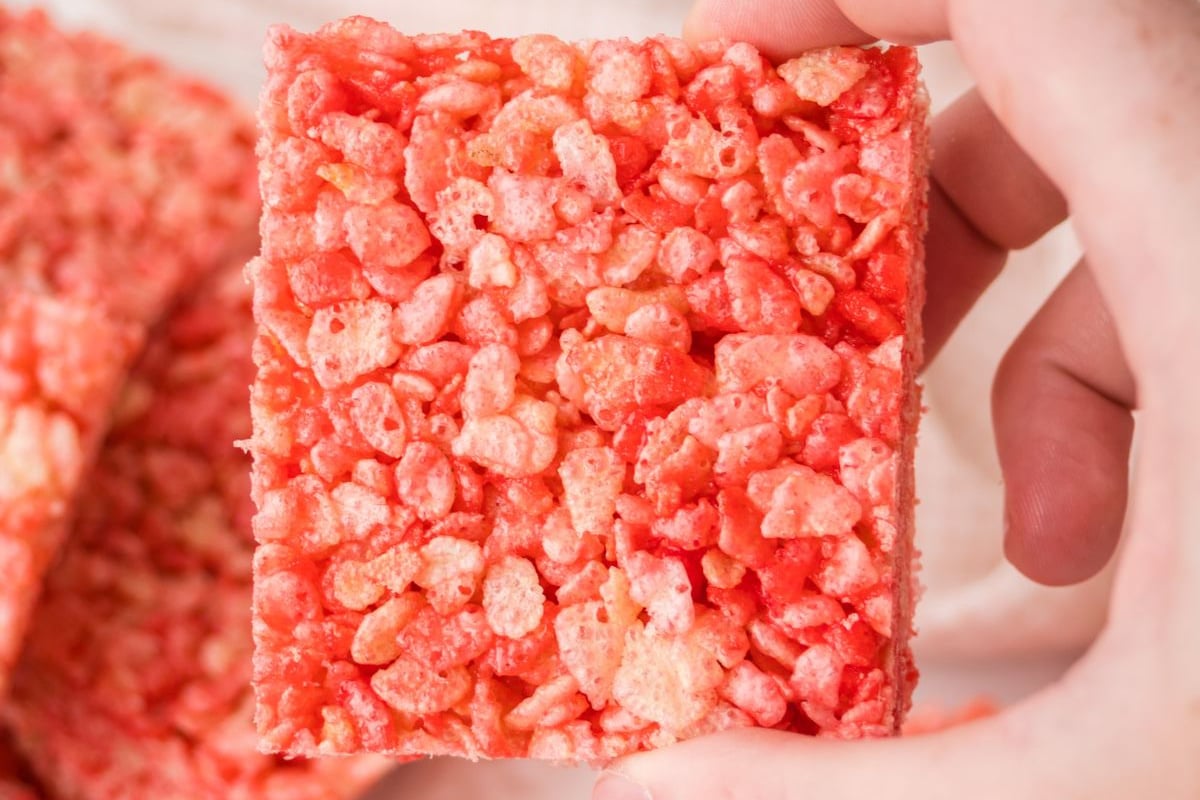 A rice krispie square held in the air.