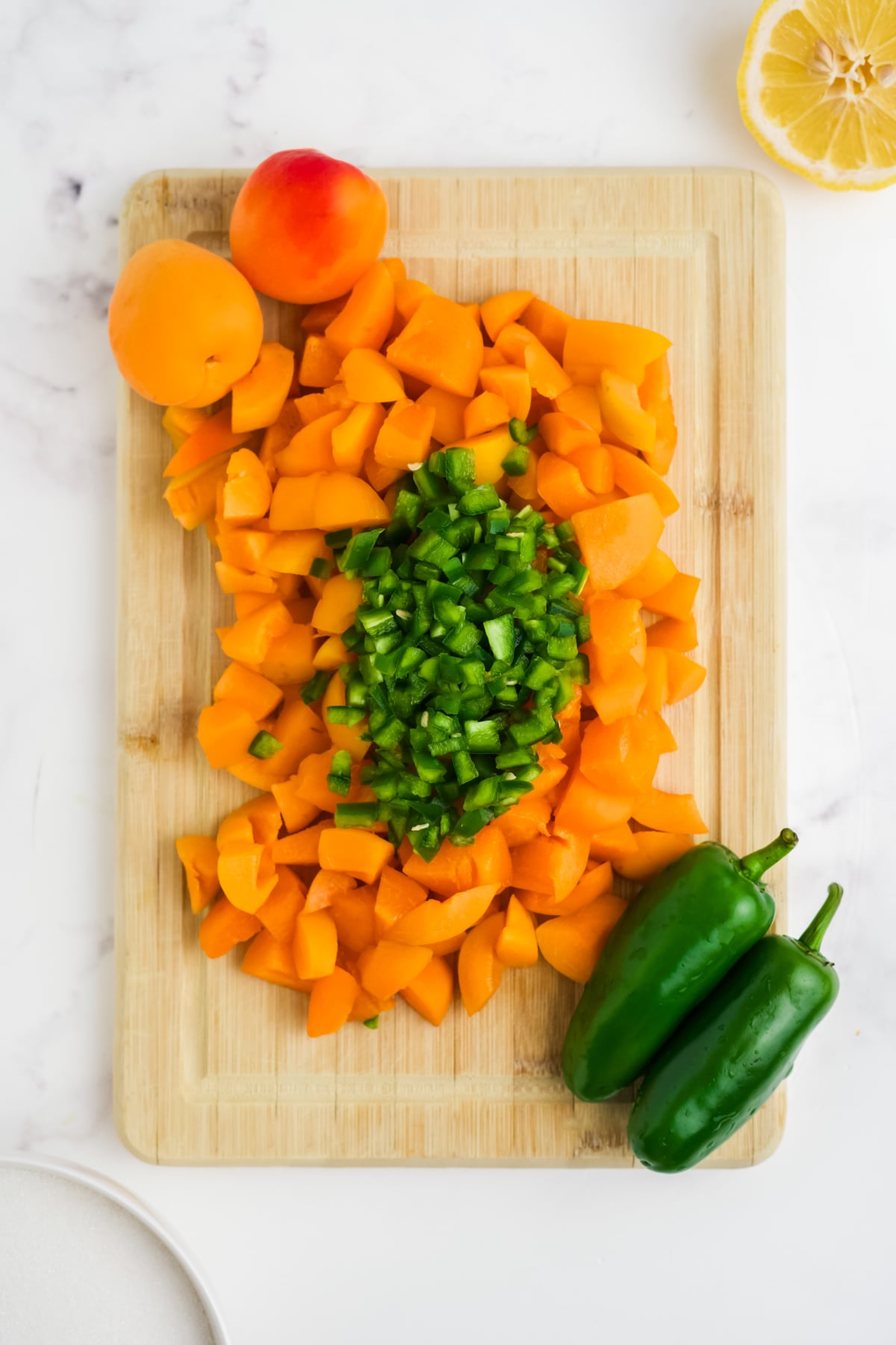 Apricots and jalapenos chopped up on a cutting board.