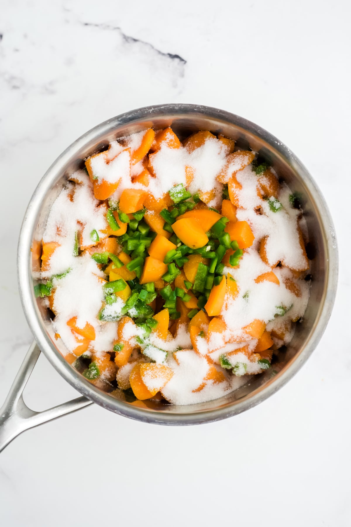 Apricots, jalapenos, sugar, and lemon juice in a pot.
