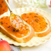 Apricot jalapeno jam being spread onto bread.
