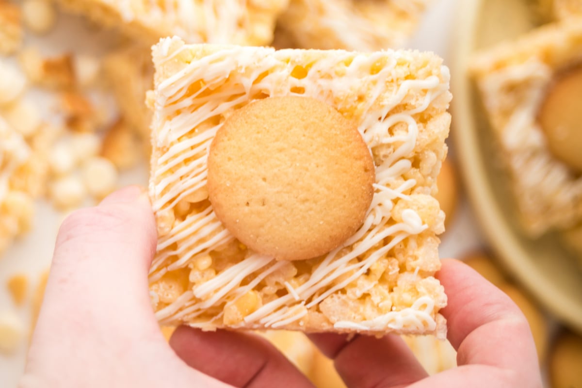 A rice krispie square held in the air.