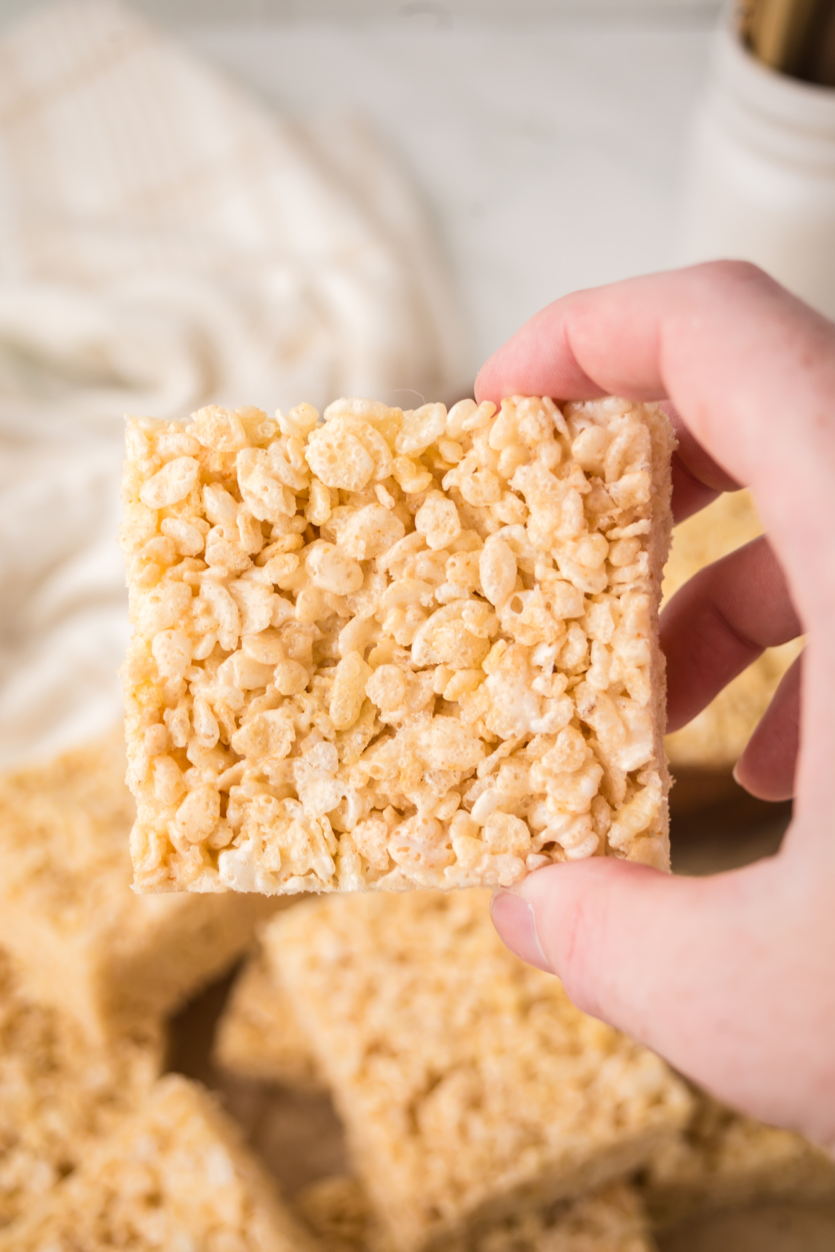 A square Rice Krispie treat held in the air