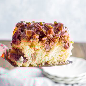 A slice of pecan upside down cake held up in the air.