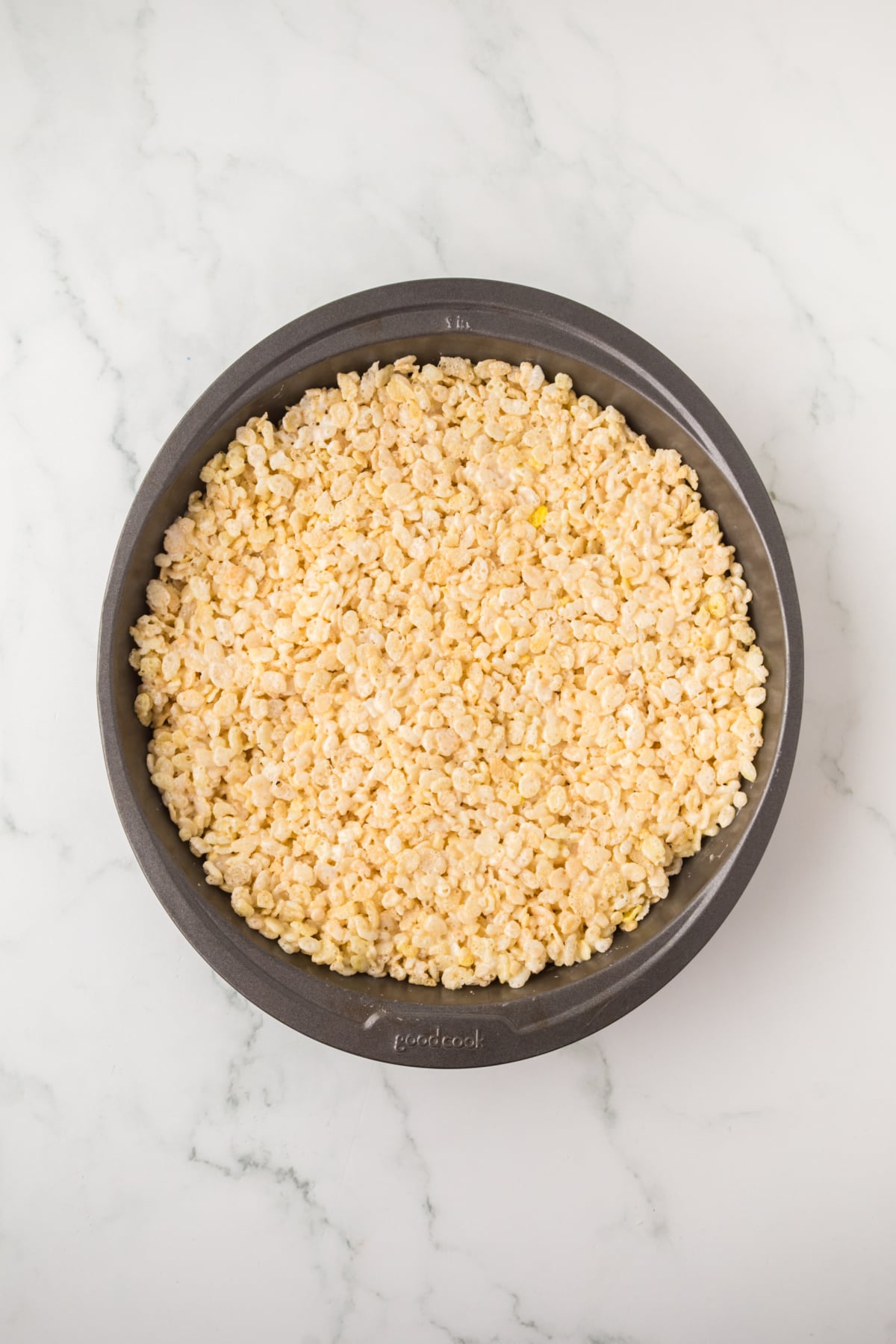 An 8-inch cake pan filled with a Rice Krispie treat cake layer