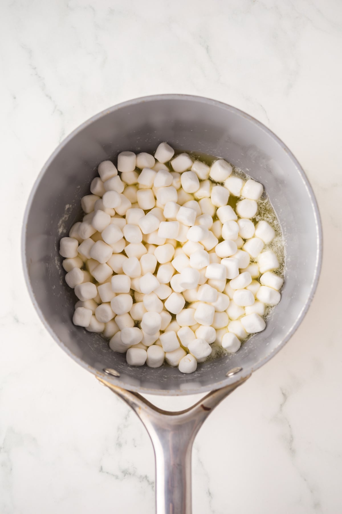 Marshmallows and vanilla melting in saucepan.