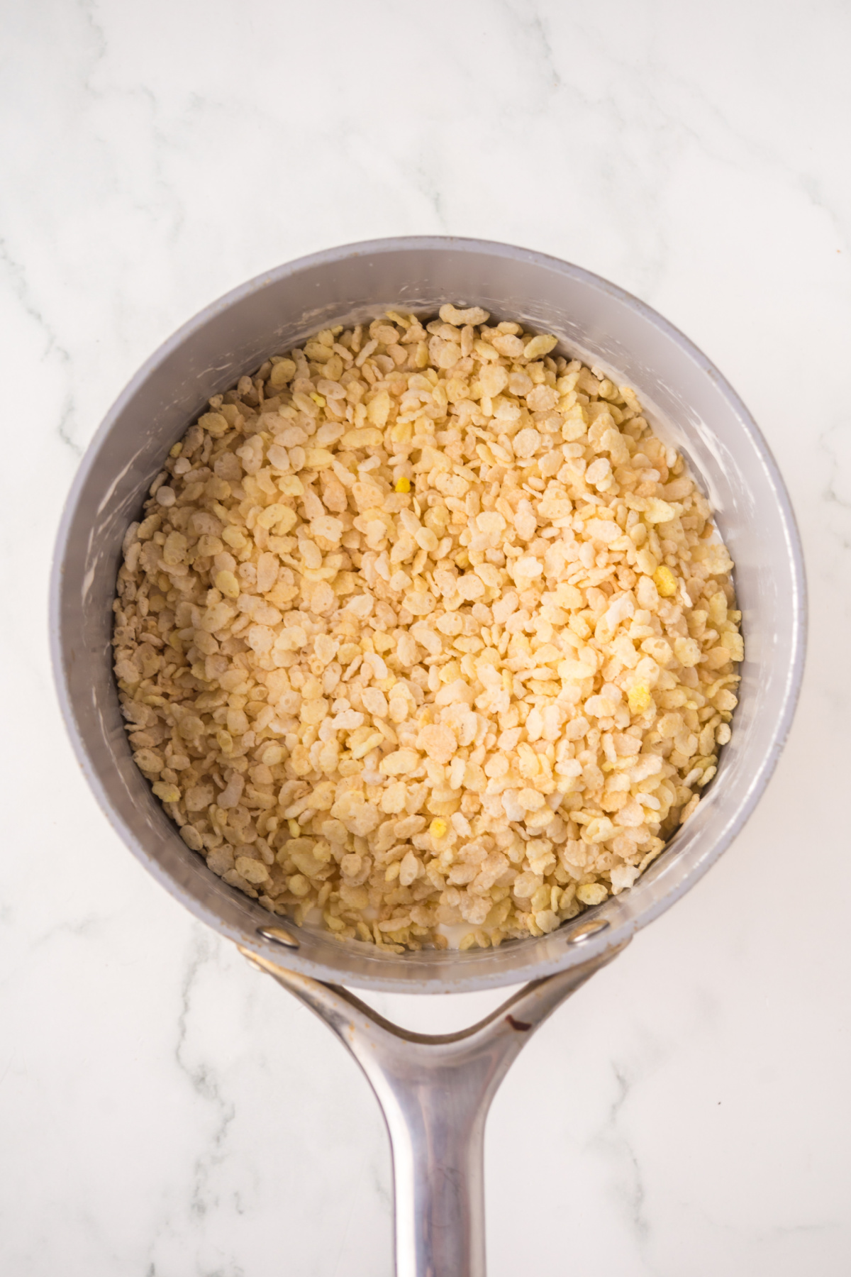 Rice krispies added to saucepan off heat.