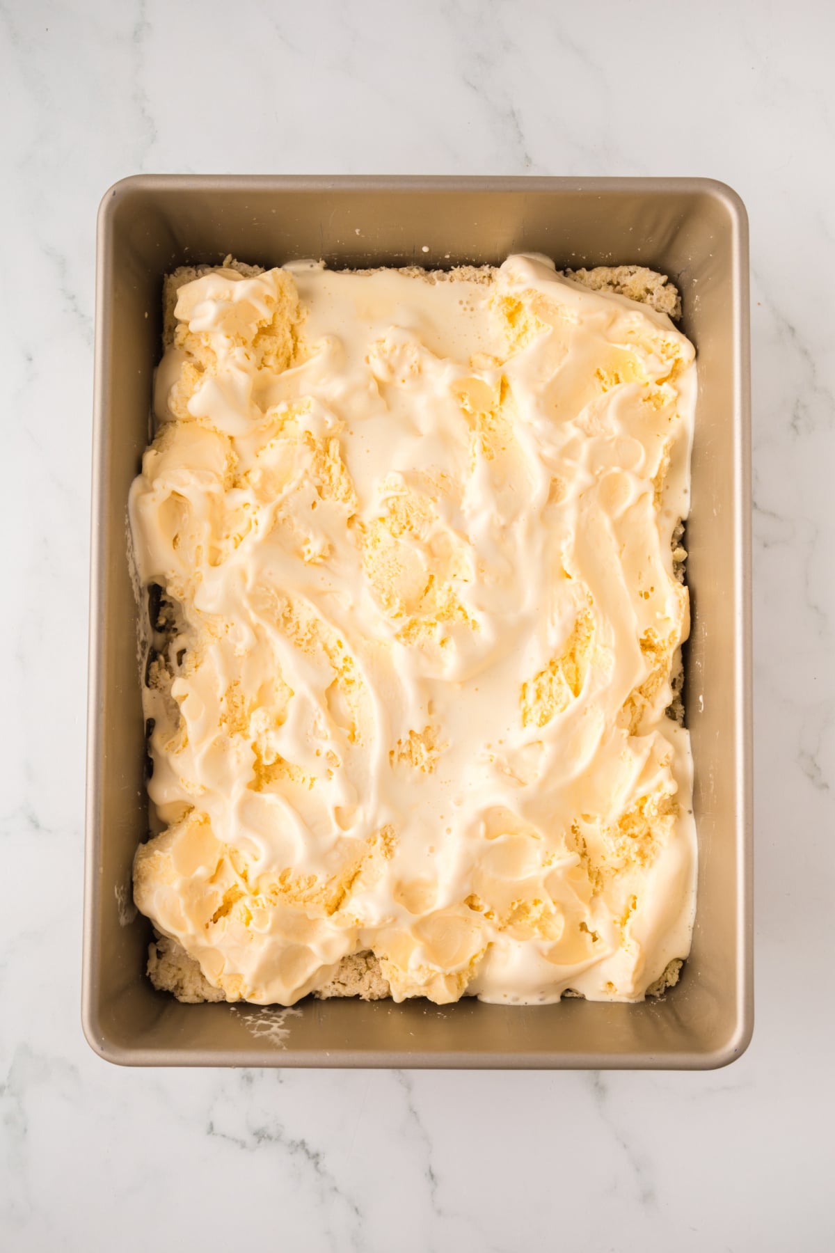 Ice cream spead on top of bottom rice krispies layer.