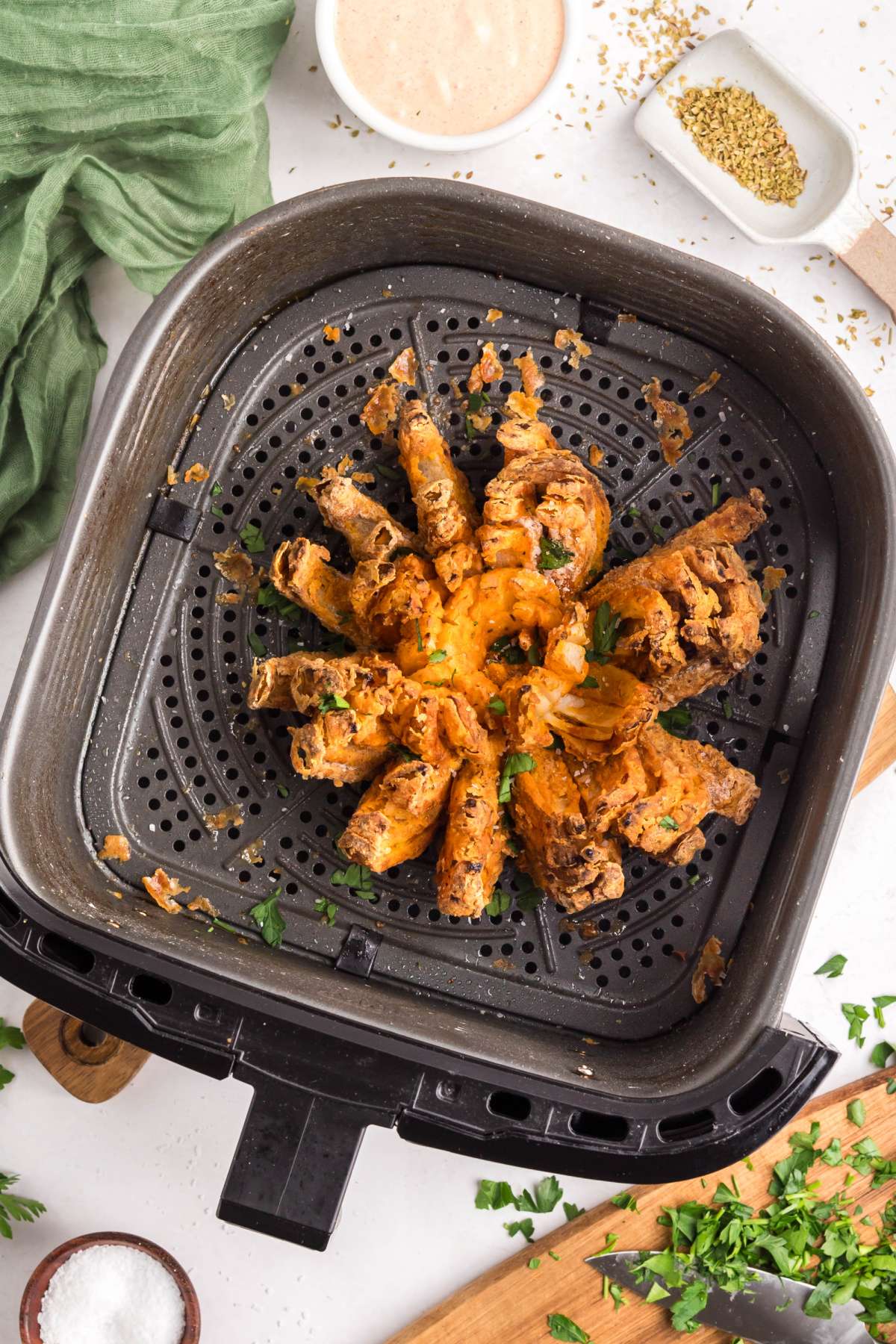 The onion cooked in the air fryer with parsley on top.