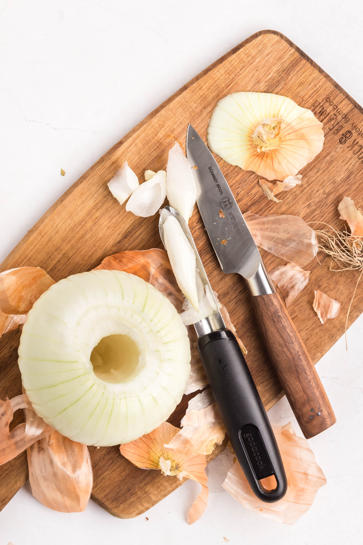 Onion peeled and cored on a cutting board.