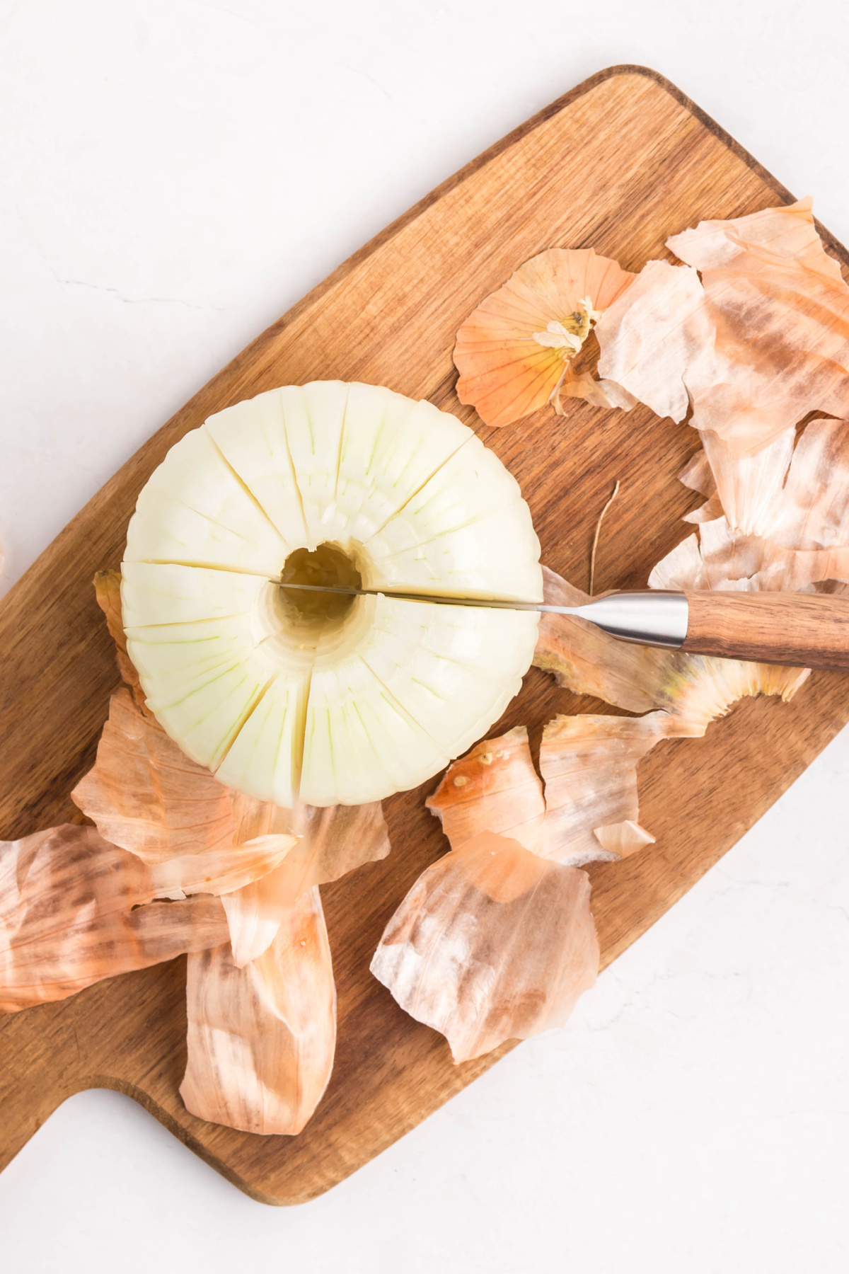 Onion cut all the way around on a cutting board.