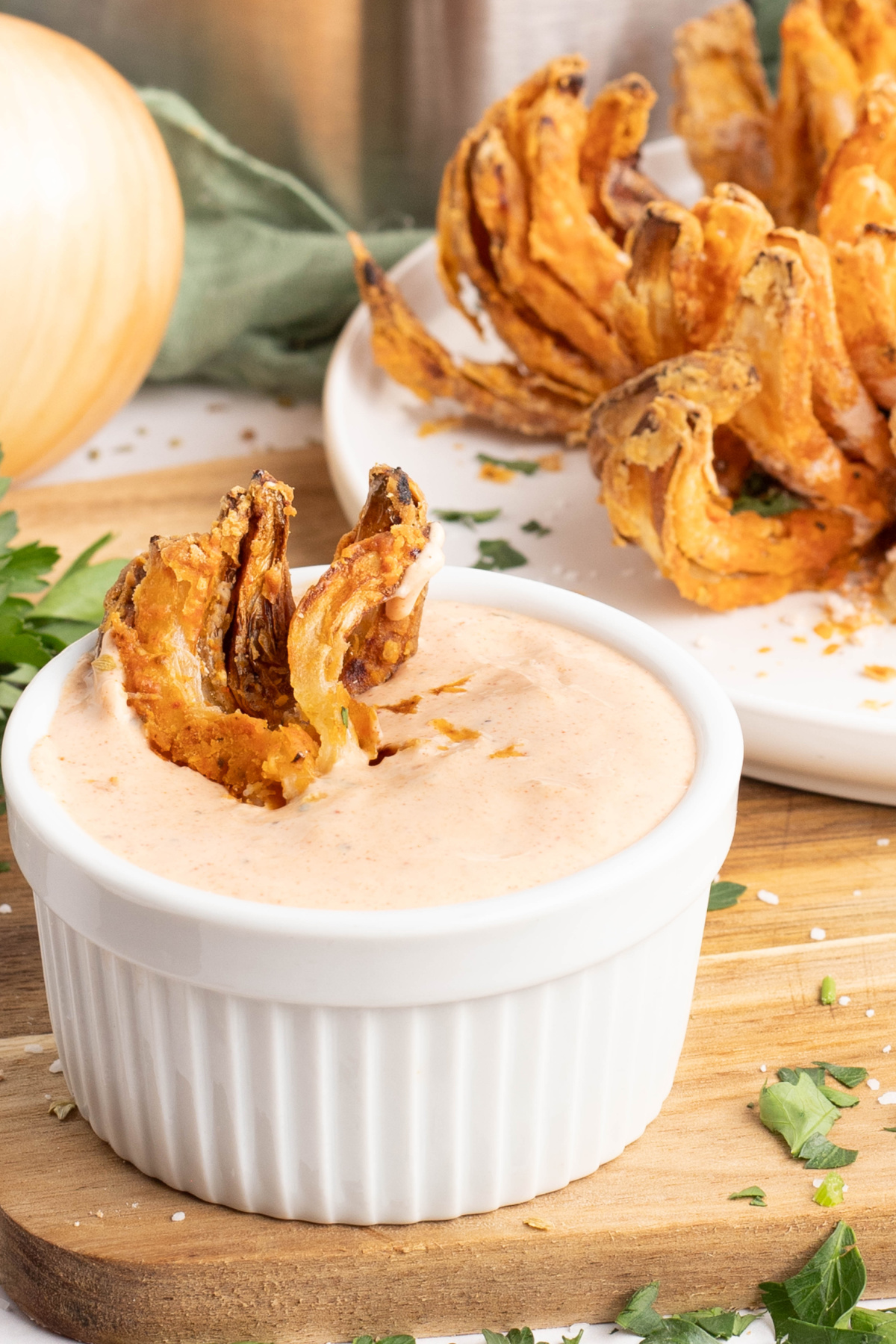 Crispy onion being dipped into sauce.