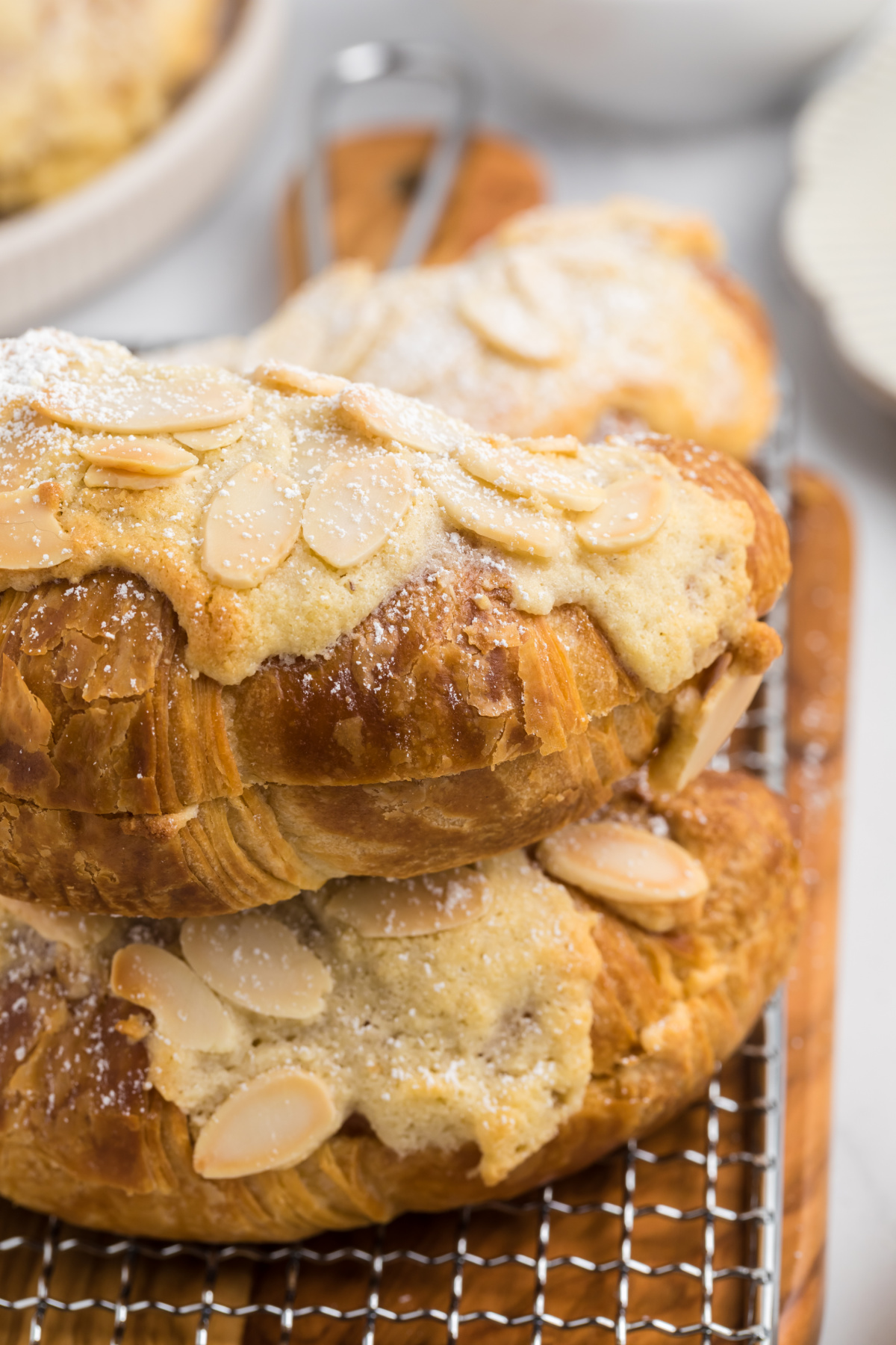 A croissant with almonds and filling on it.