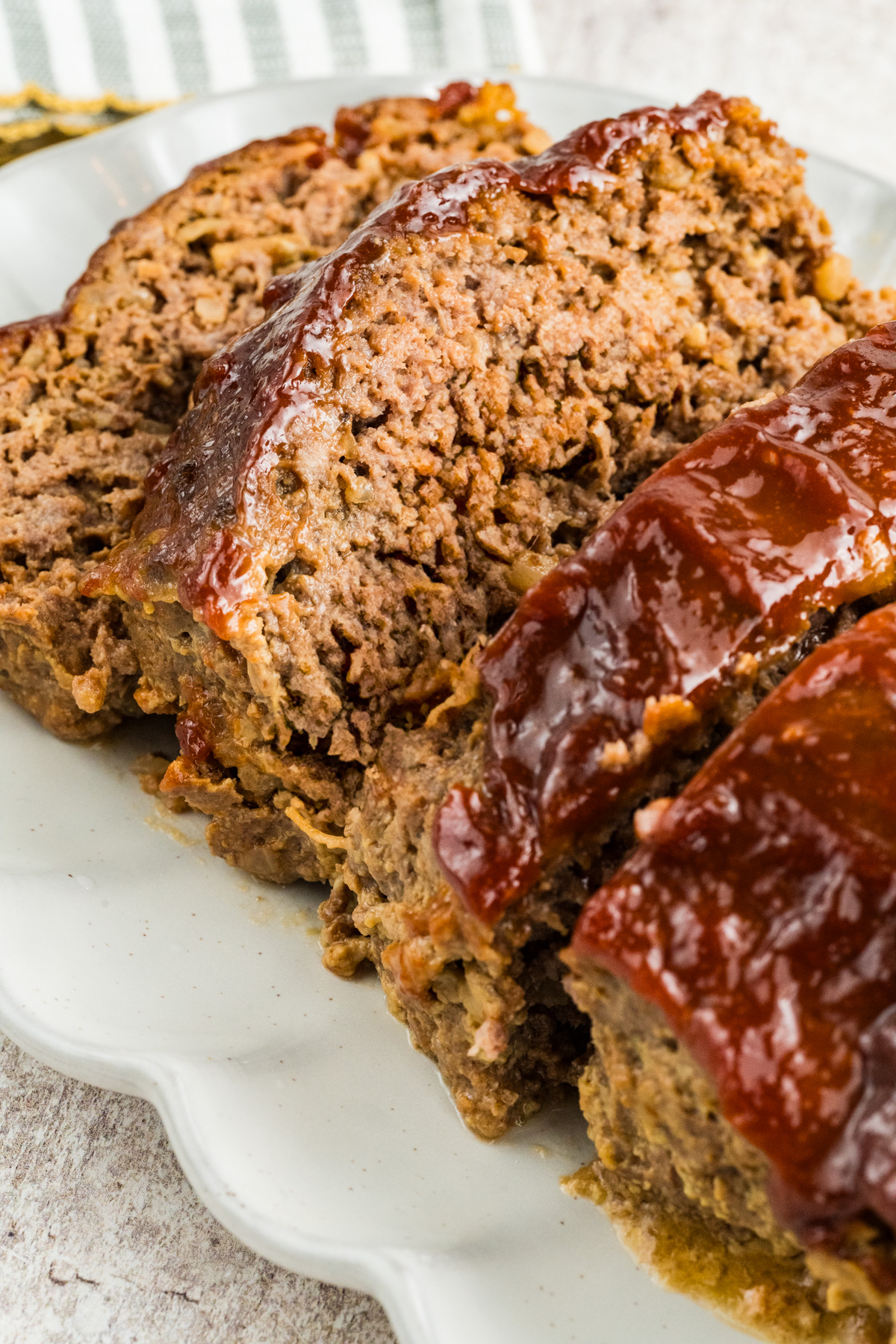 Meatloaf sliced with glaze on top on a plate.