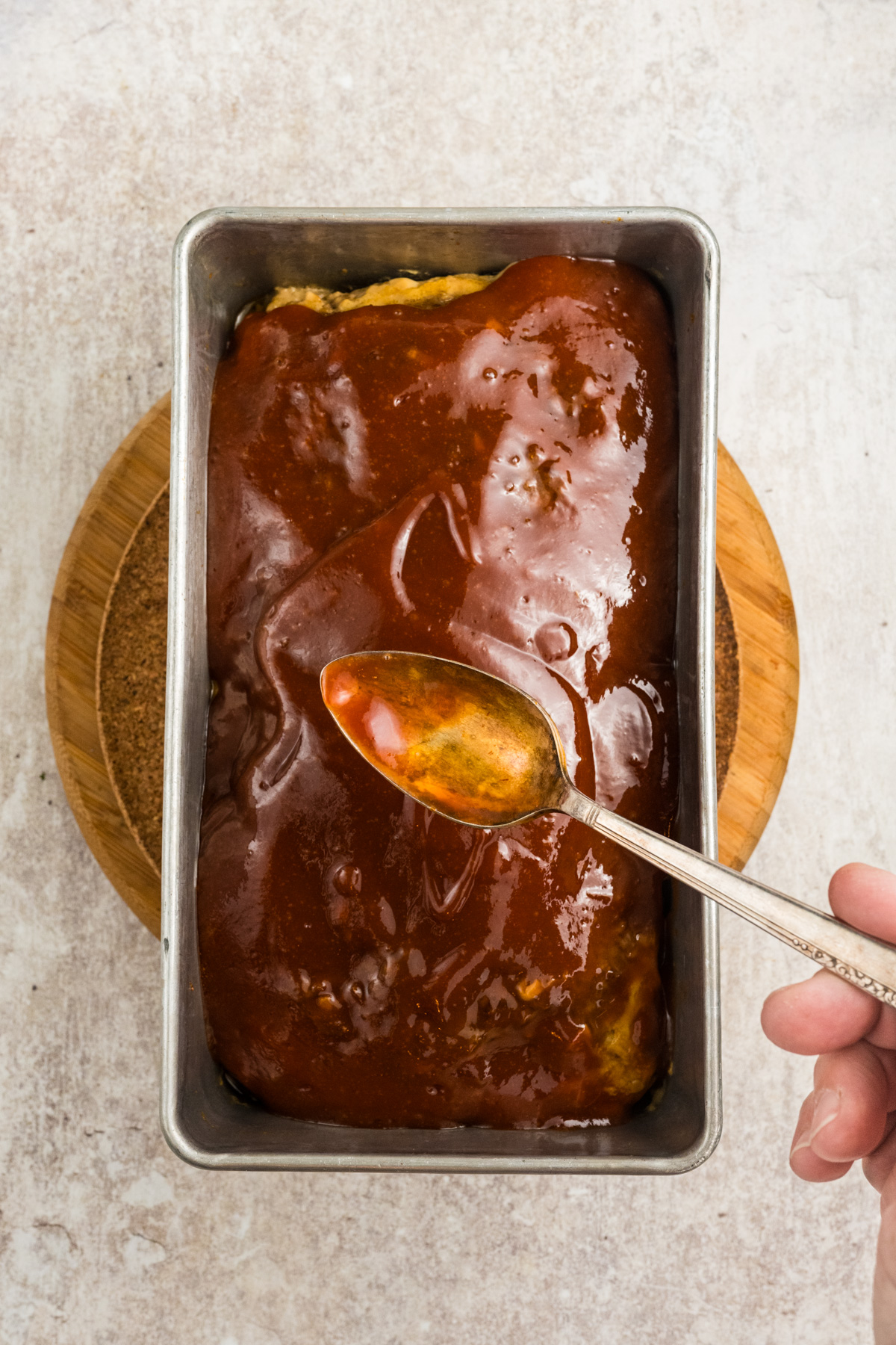 The glaze spooned over the top of the meatloaf.