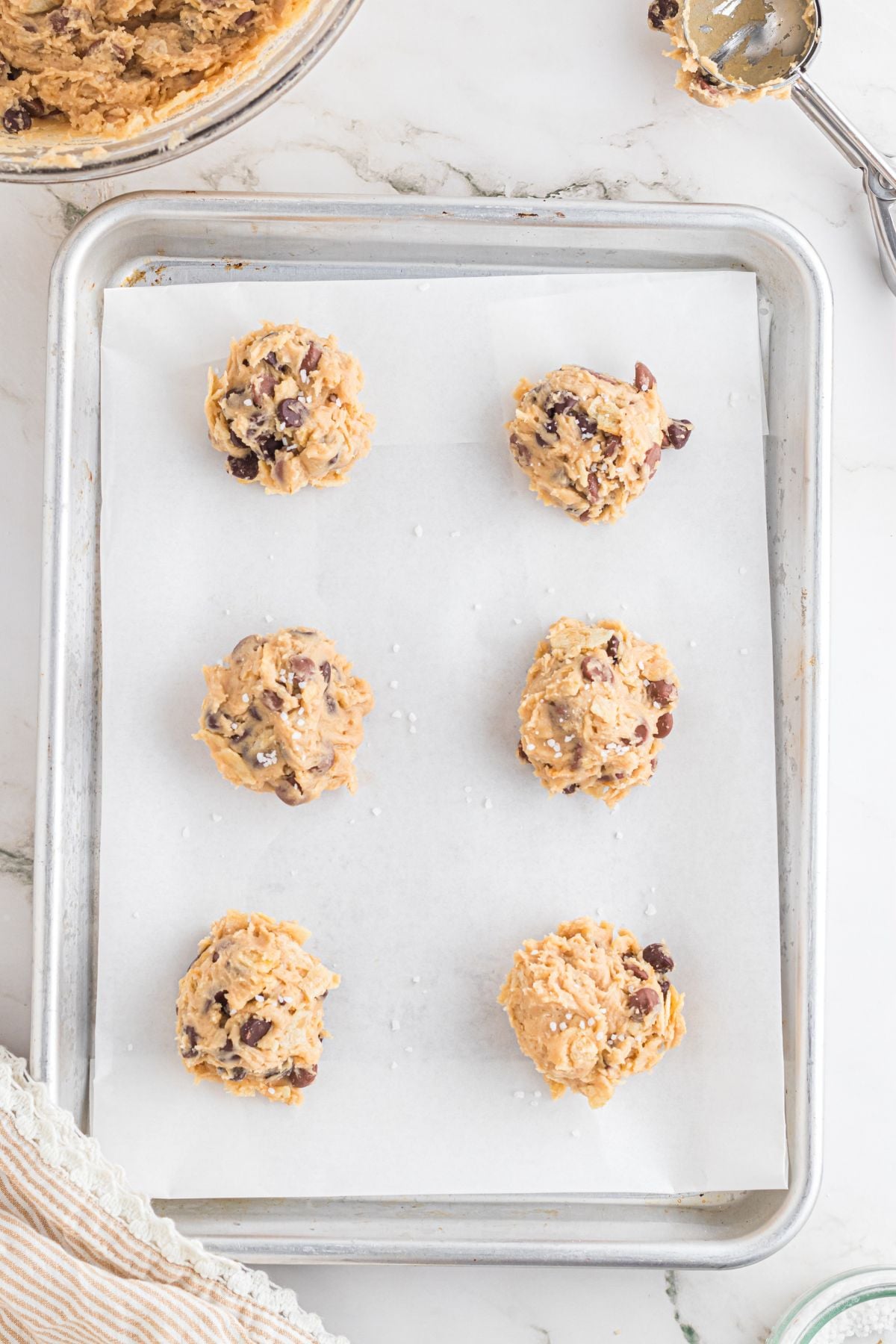 The cookie dough scooped onto the prepared baking sheet.