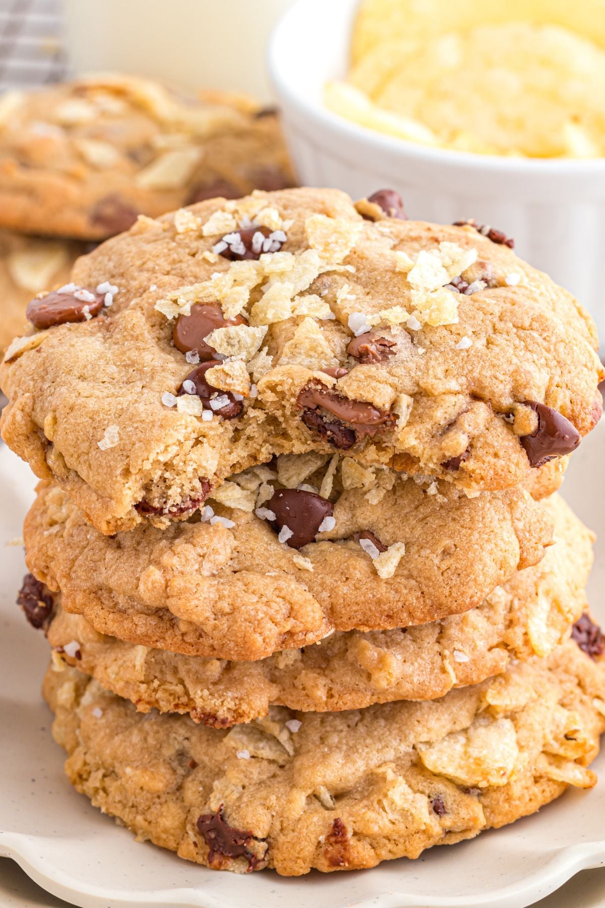 A stack of potato chip cookies with a bite off of the top cookie.